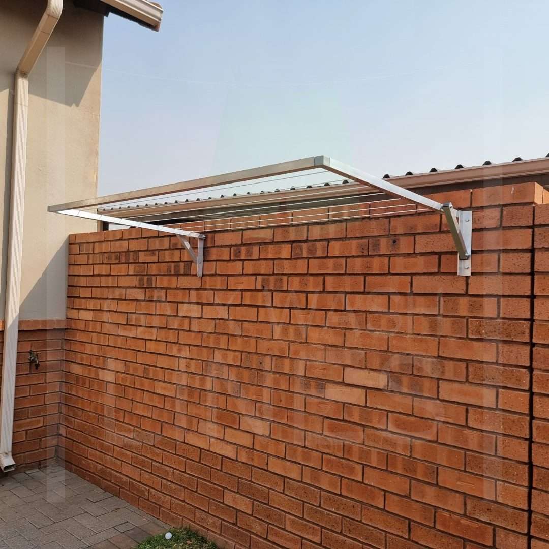 Robust wall-mounted washing line along a garden fence.