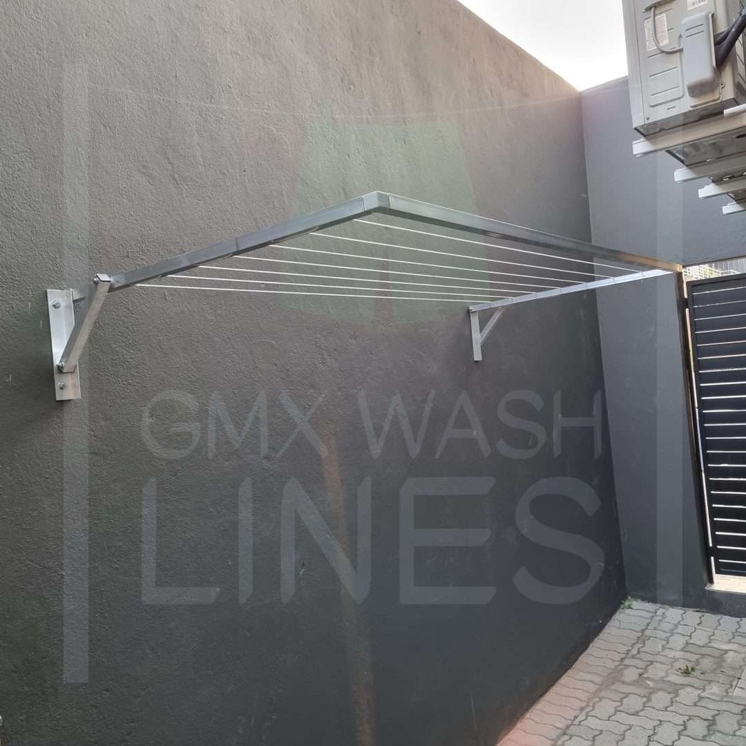 Extended wall-mounted washing line on a textured wall.