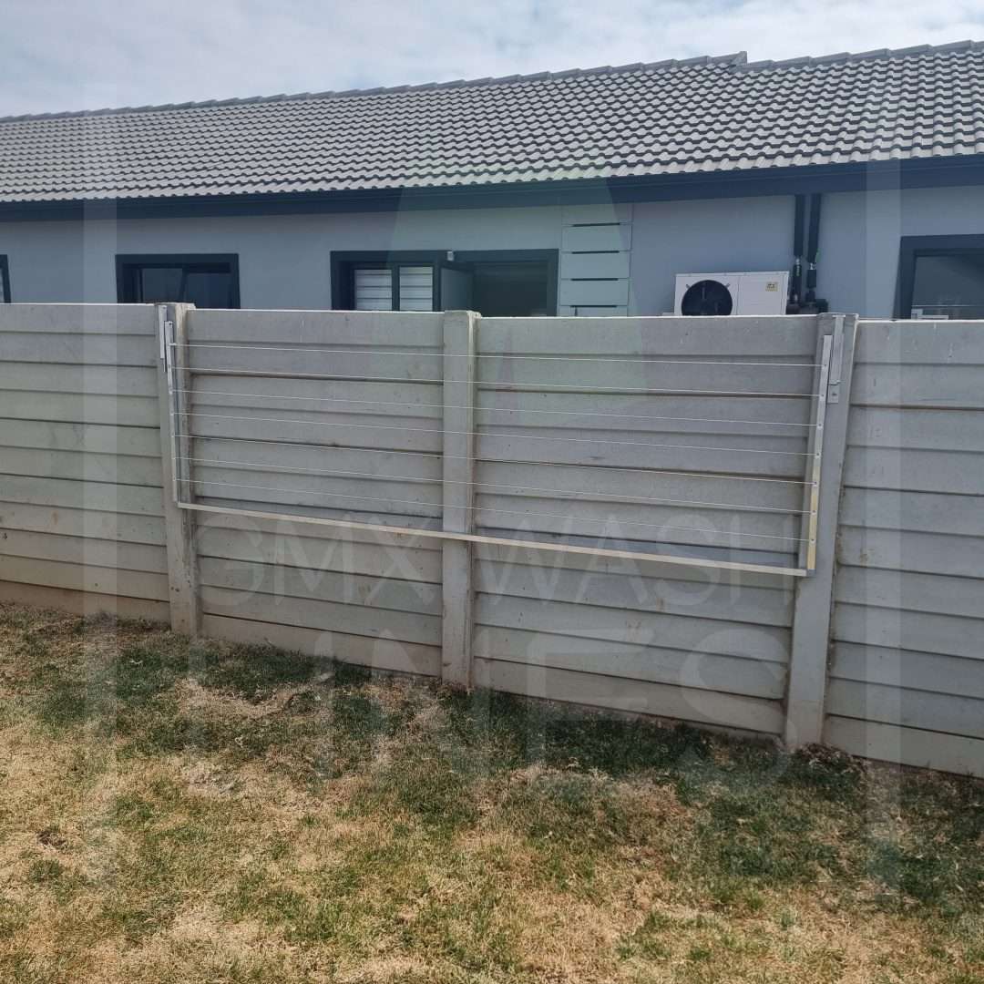 Wall-mounted Foldaway Washing Line in a residential outdoor setting.