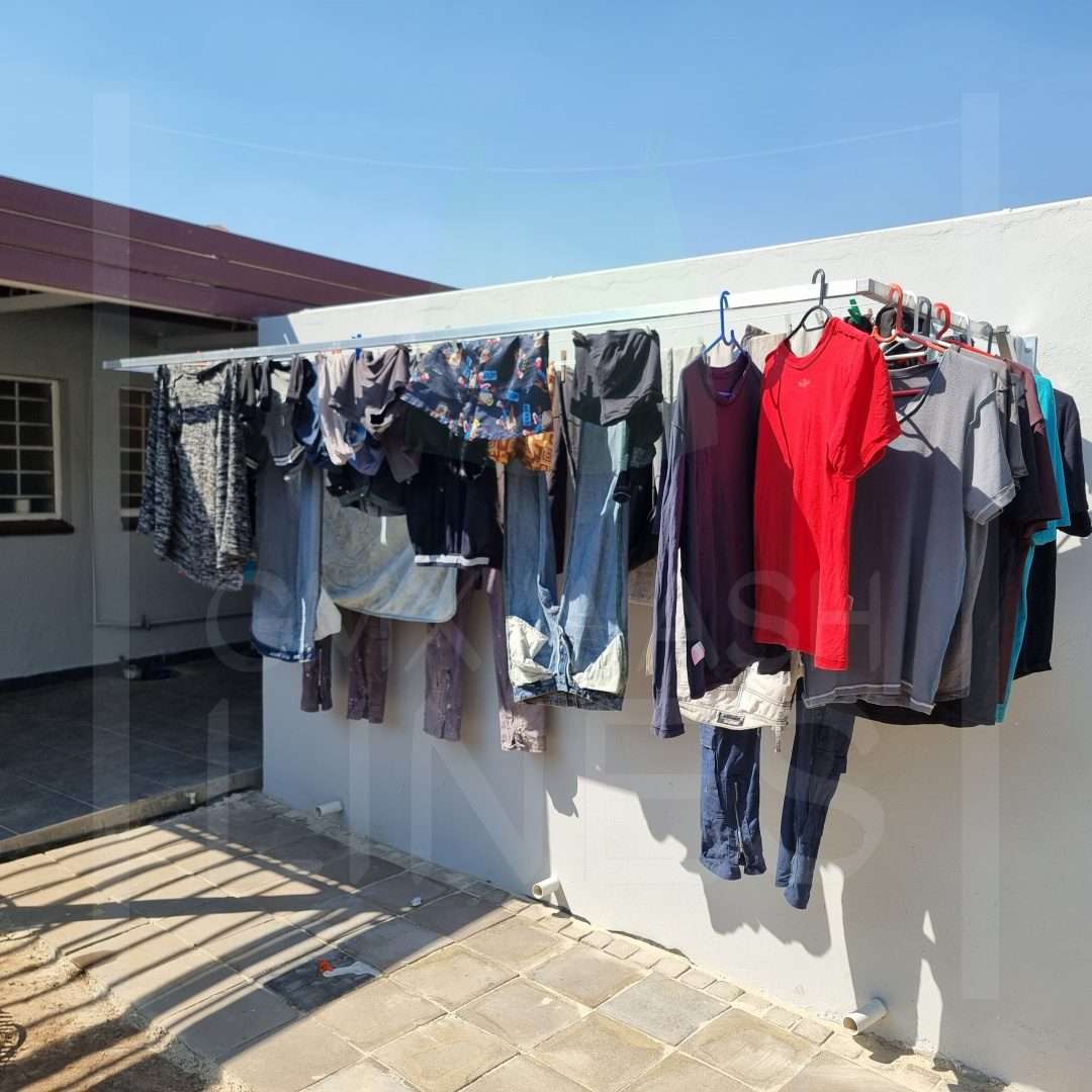 Loaded aluminium wash line with clothes in a sunny backyard