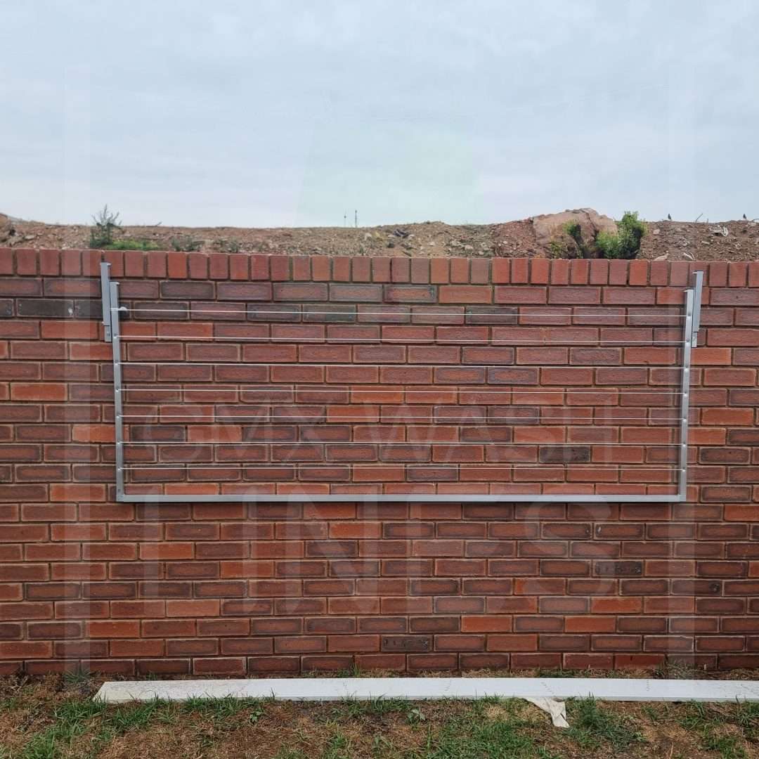 Collapsible Aluminum Washing Line against brick wall.