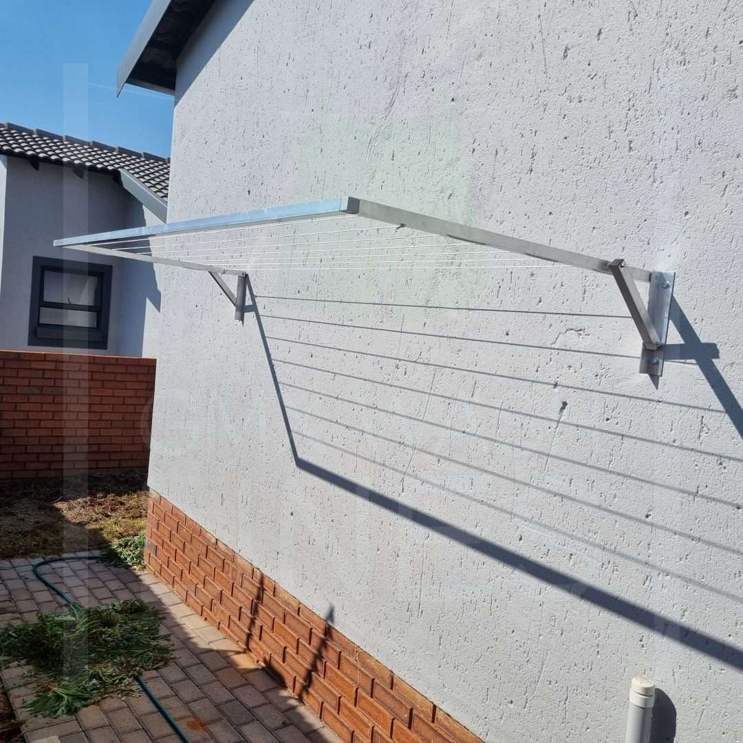 Extended aluminum wall-mounted wash line on a sunny day