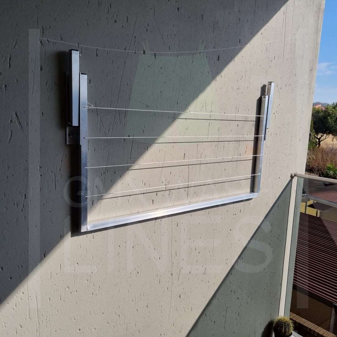 Foldable wall-mounted wash line on a textured cream wall